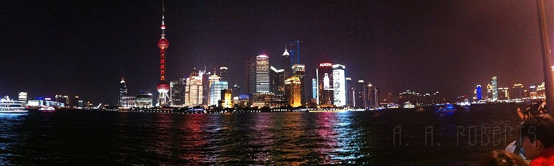 sh25.jpg - Here is a panoramic view of the west side of the Huangpu river.  The television tower is also reffered to as the pearl tower... that's the red one... with the two large speheres... get it?